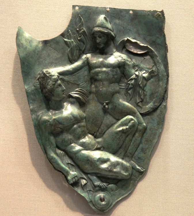 Bronze, Cheekpiece of helmet, 400BC, warrior with cape, pileus and shield holds.jpg